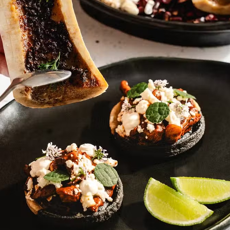 Bone marrow and two sopes topped with greens and white cheese at Carne & Hueso in North Park.